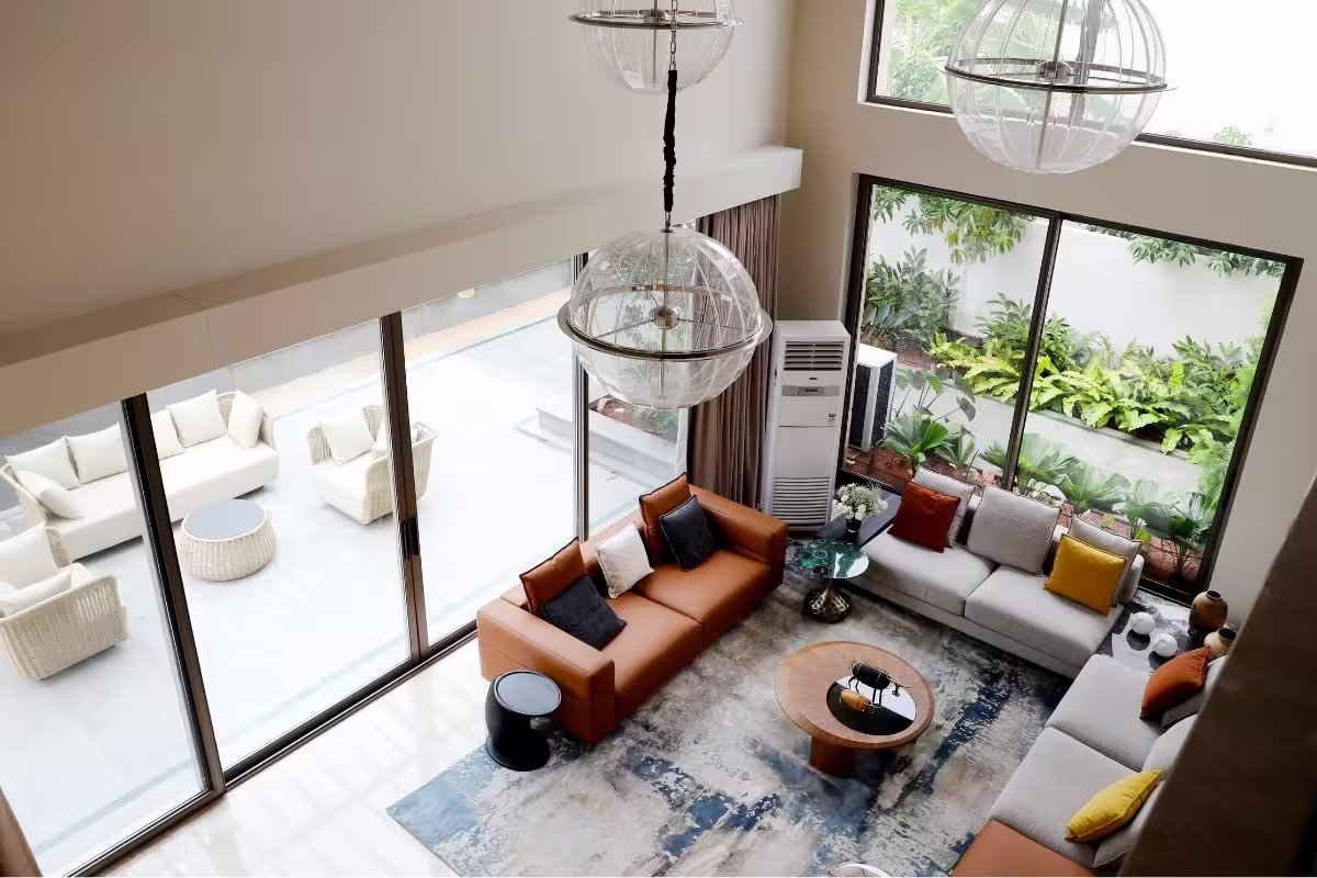 Living Feng Shui que invita a la comunicacion con los sofa en semi circulo en colores terracota y beige, dos ventanales con vistas al jardin y terraza